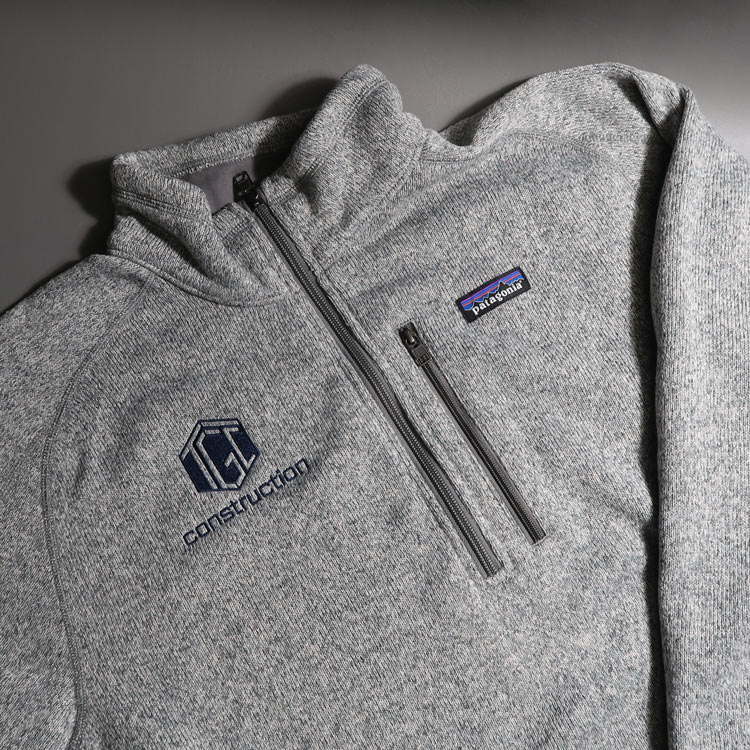 Gray quarter-zip Patagonia sweater featuring an embroidered TGC Construction logo on the left chest.