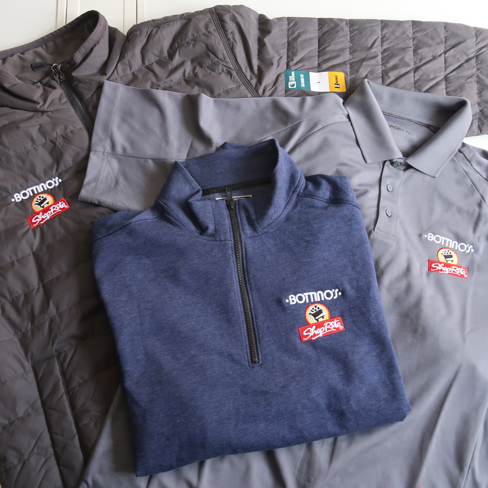 Three Bottino's ShopRite branded shirts including a quilted jacket, a gray polo, and a navy quarter-zip pullover.