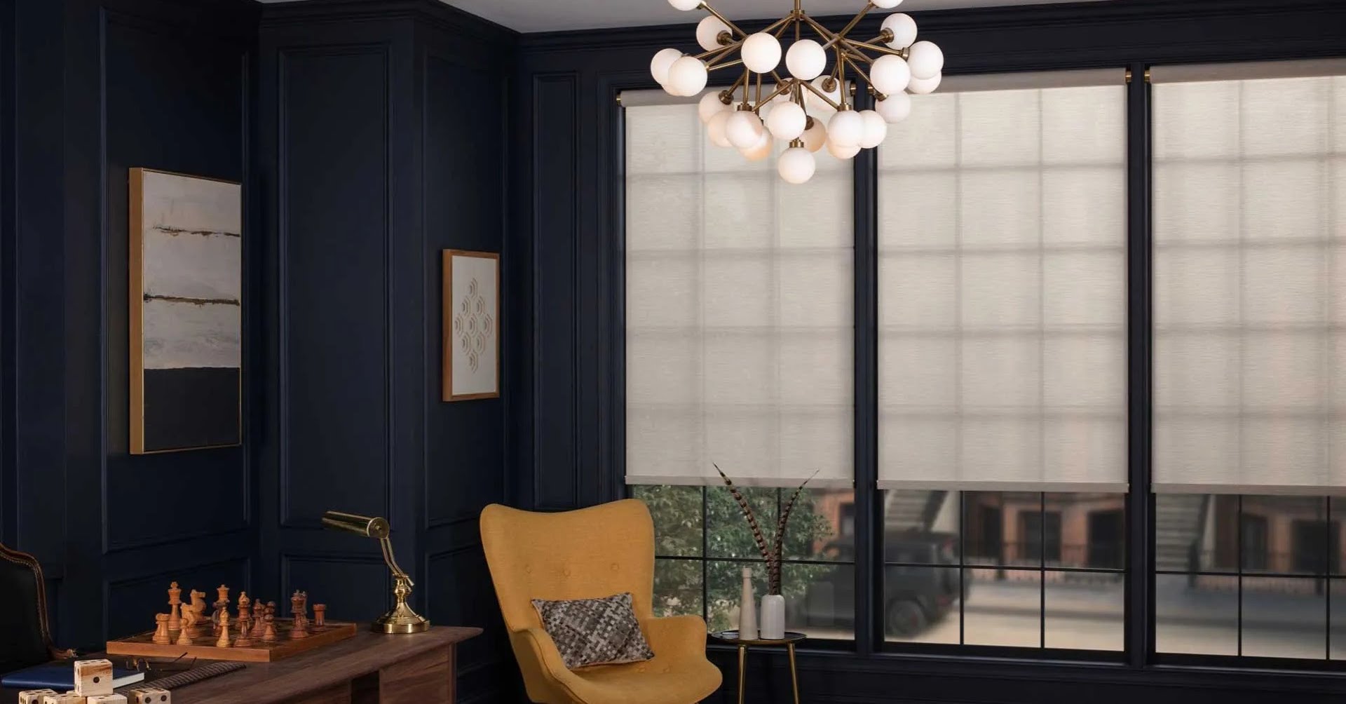 Room with modern chandelier, yellow chair, and window shades.