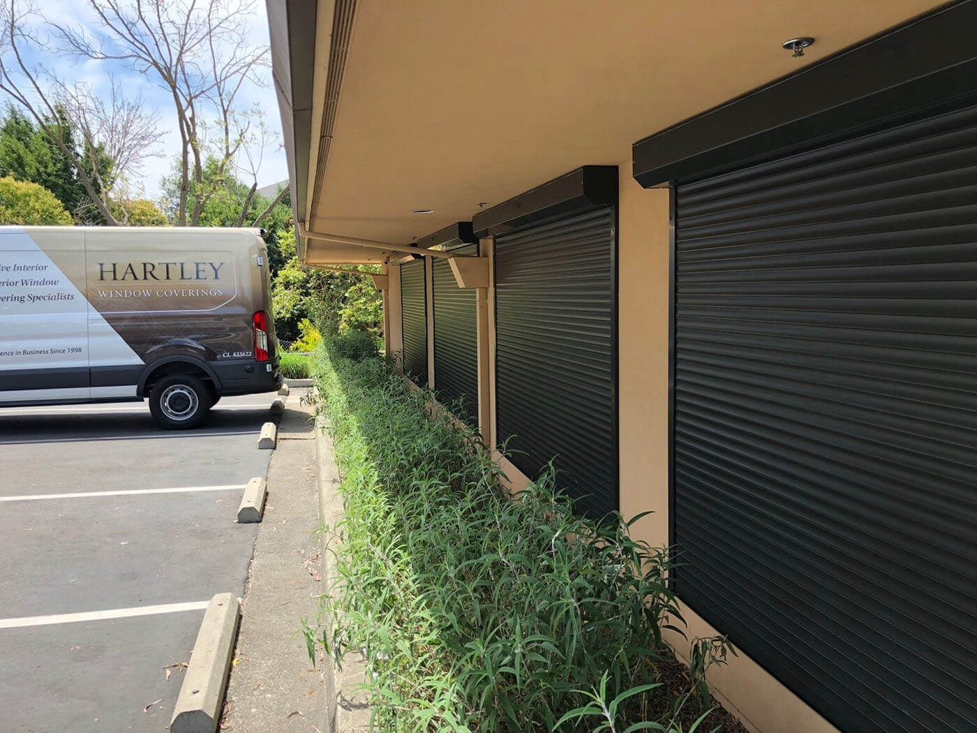 Rolling shutters on building exterior, Hartley van nearby.