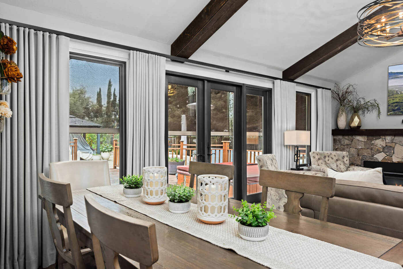 Dining room with white drapes, side panels, and wooden table in Santa Rosa home.