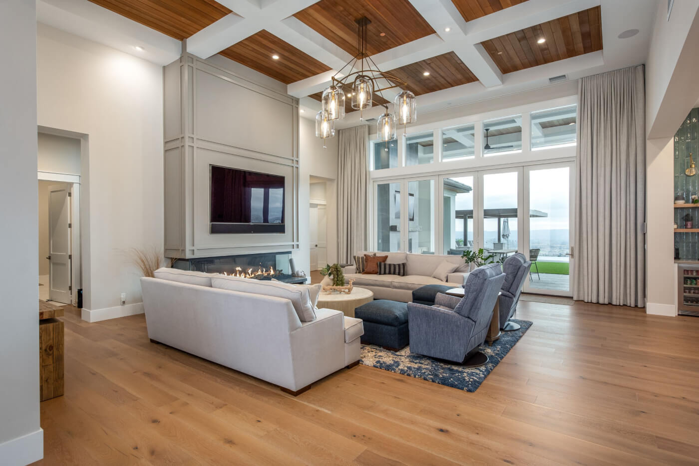Spacious living room with large windows, drapes, and lake view.