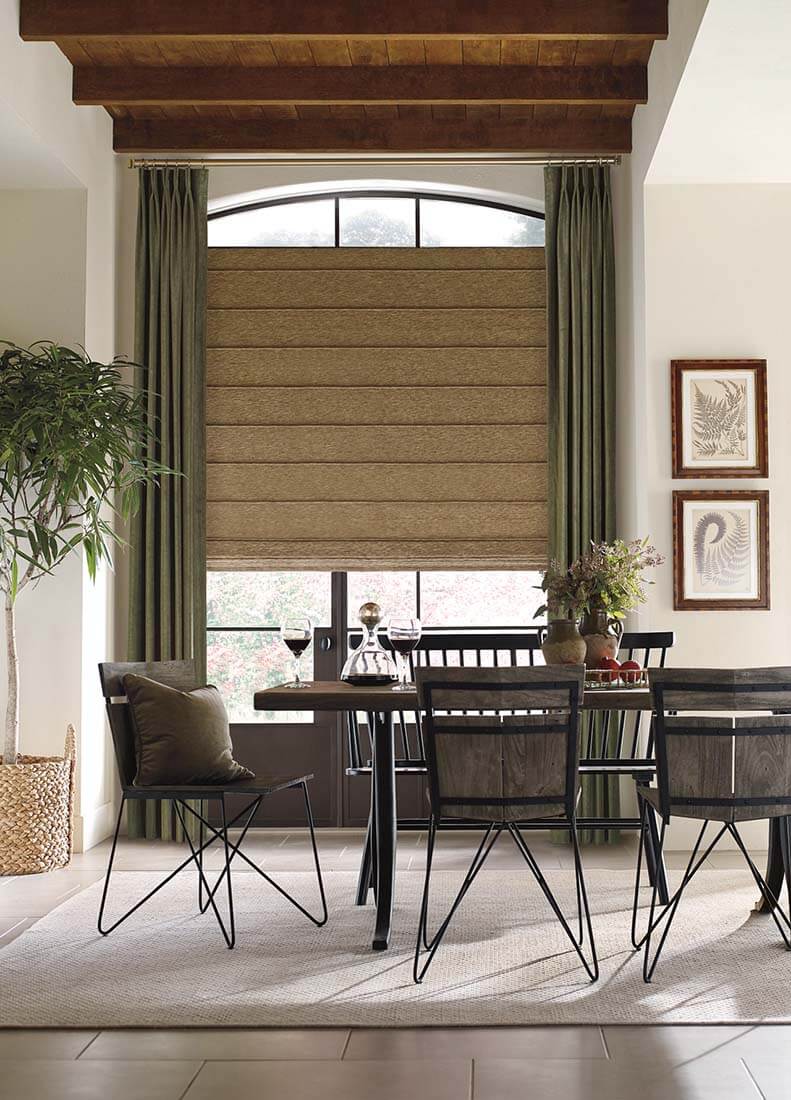Dining area with green drapes, Roman shade on an arched window.