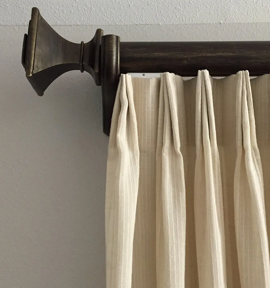 Elegant beige drape on wooden rod.