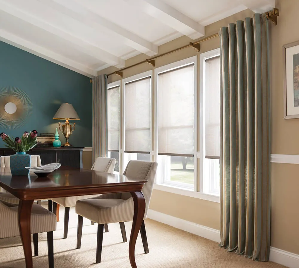 Dining room with blinds, teal drapes, beige side panels
