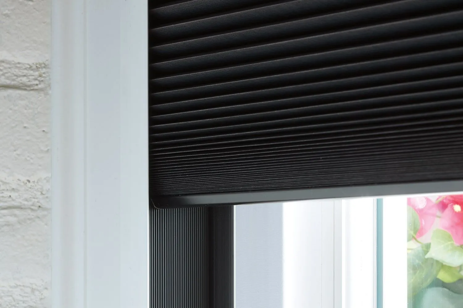 Black honeycomb shade partially lowered
