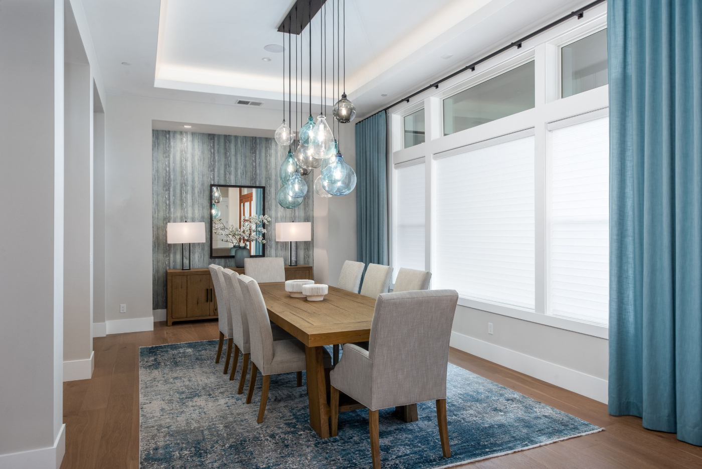 Dining room with cellular honeycomb shades and blue curtains.
