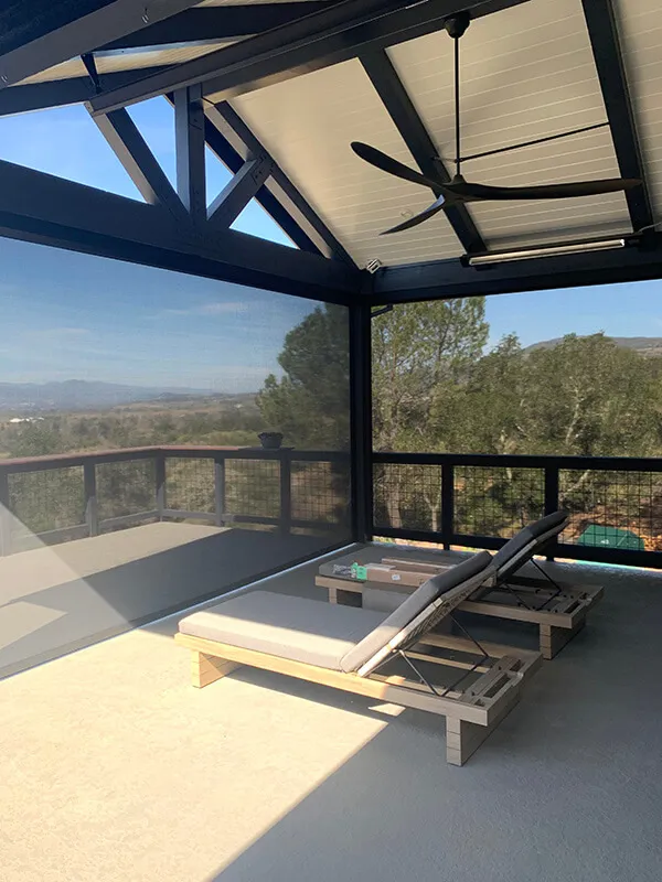 Outdoor patio with solar screens, two chaise lounges.