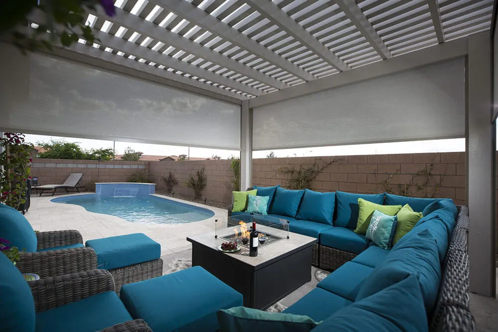 Outdoor patio with blue sectional sofa, fire pit, solar screens, pool in Santa Rosa.
