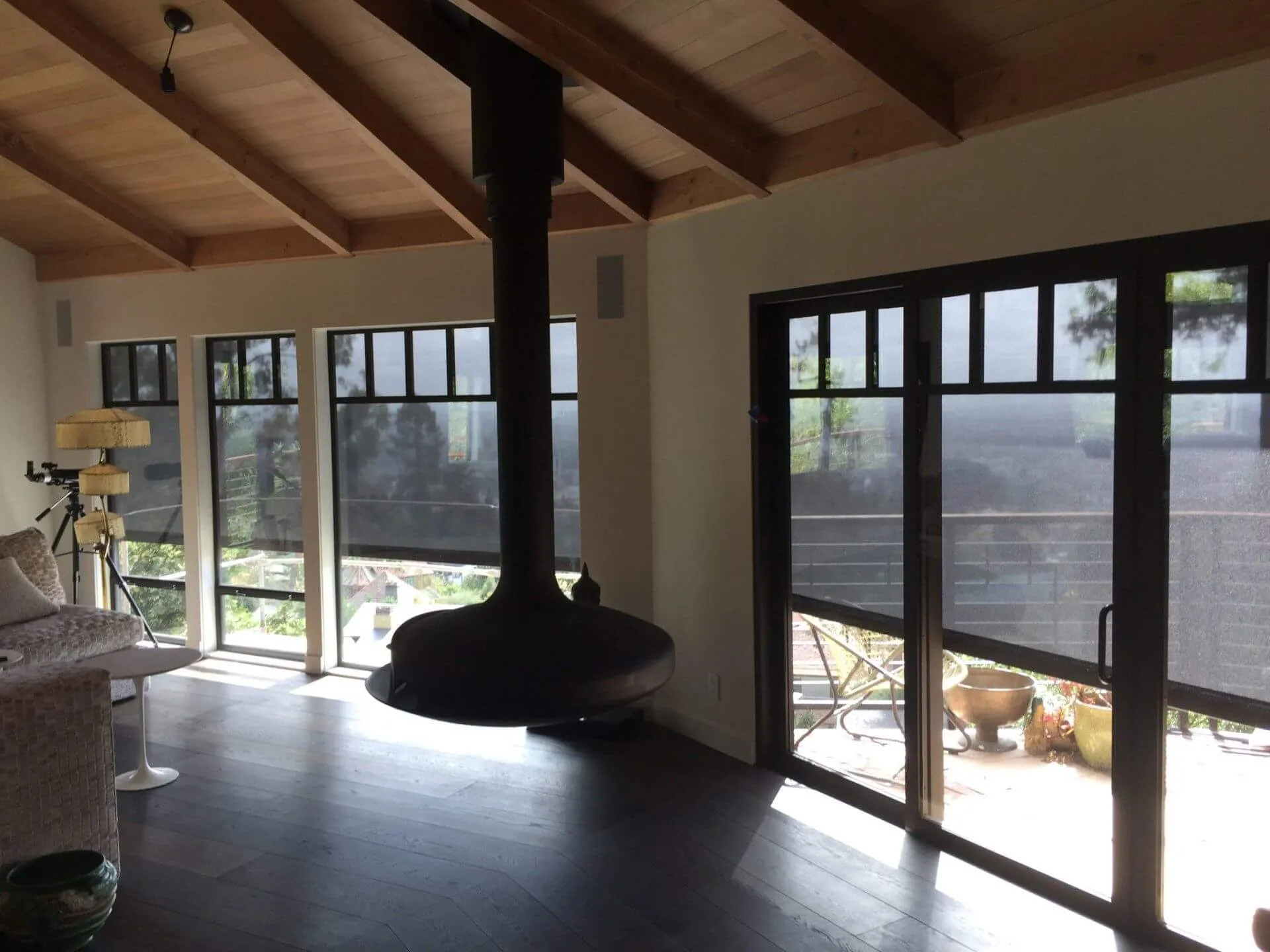 Living room with solar screens and hanging fireplace.