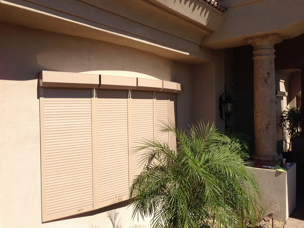 Exterior rolling shutters on house with palm plant
