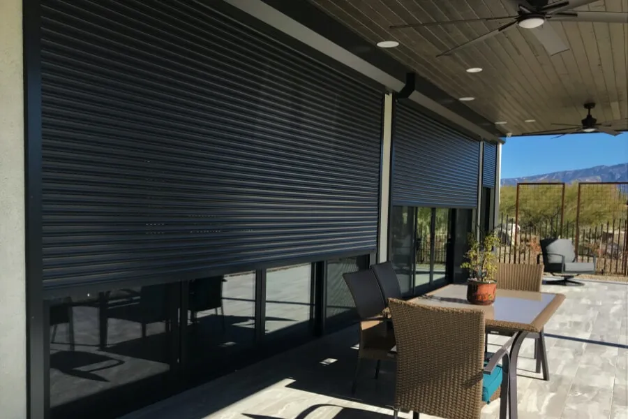 Rolling shutters on patio with outdoor furniture.