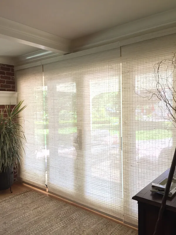 Woven wood shades on large window in living room.