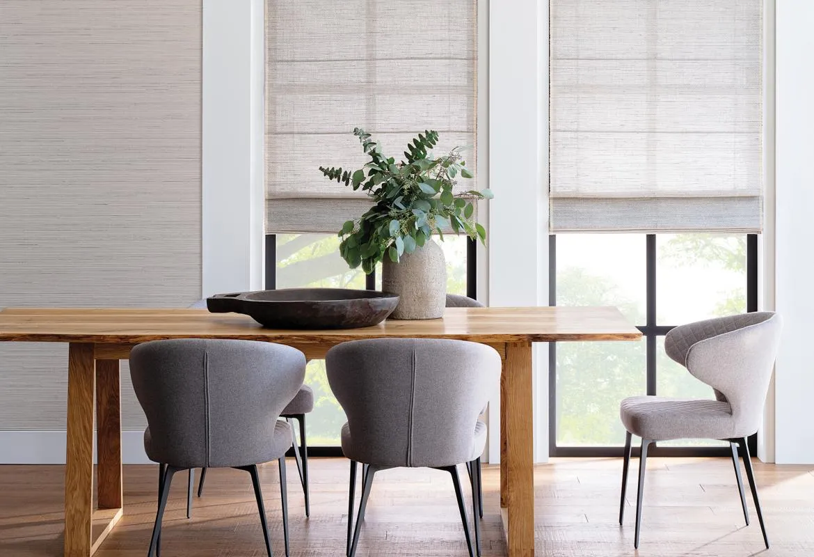 Dining area with woven wood shades on windows.