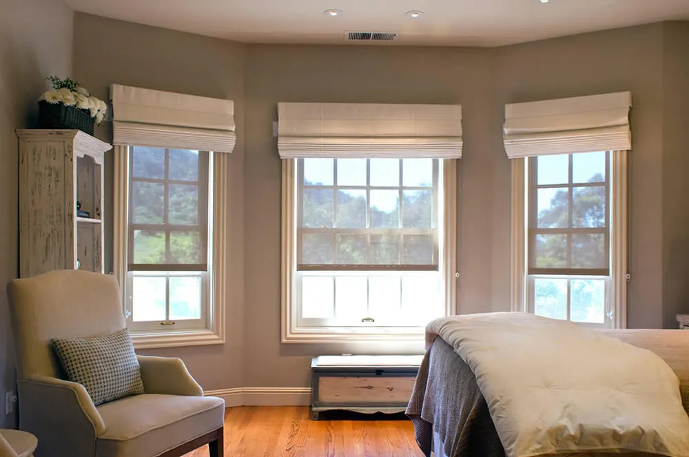 Bedroom with three windows, Roman shades.