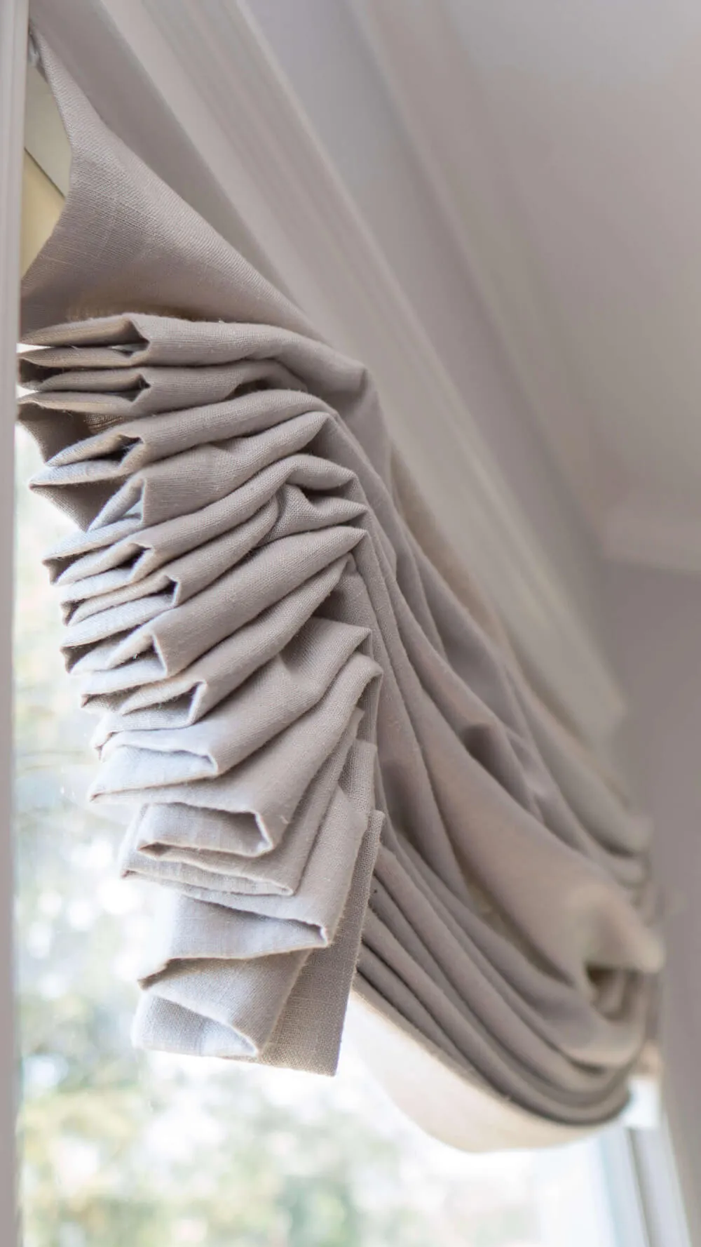 Close-up of folded beige Roman shade.