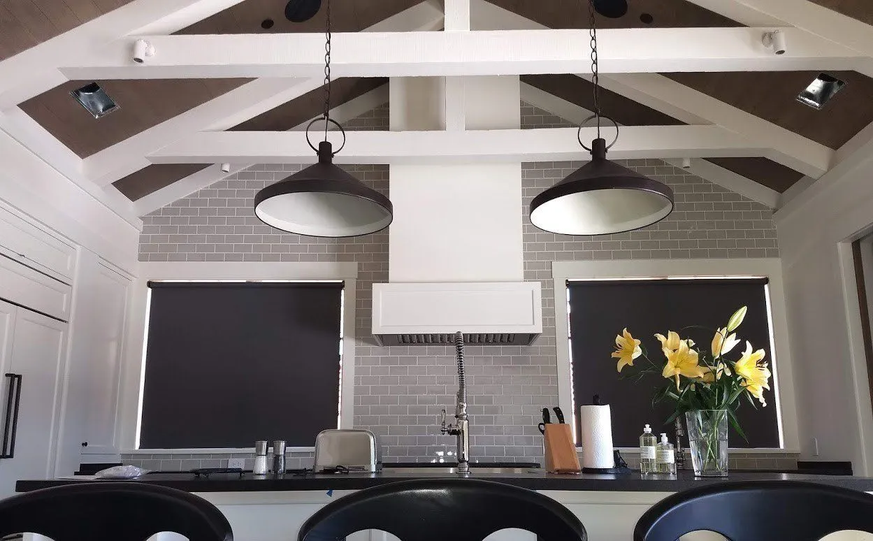 Modern kitchen with roller shades and flowers