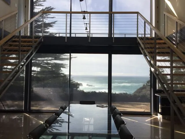 Roller shades in coastal home dining area with ocean view.