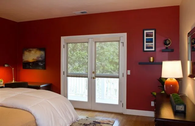Room with roller shades on double glass doors.