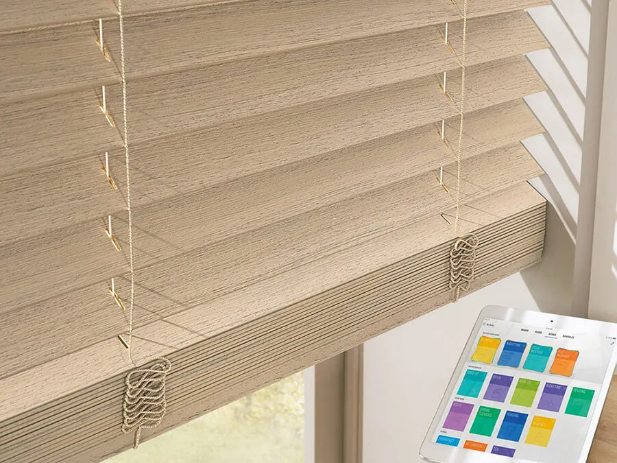 Close-up of wood blinds with an iPad showing smart home control app.