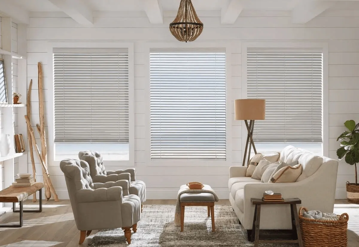 Close-up of faux wood blinds with slats partially open, filtering warm natural light.