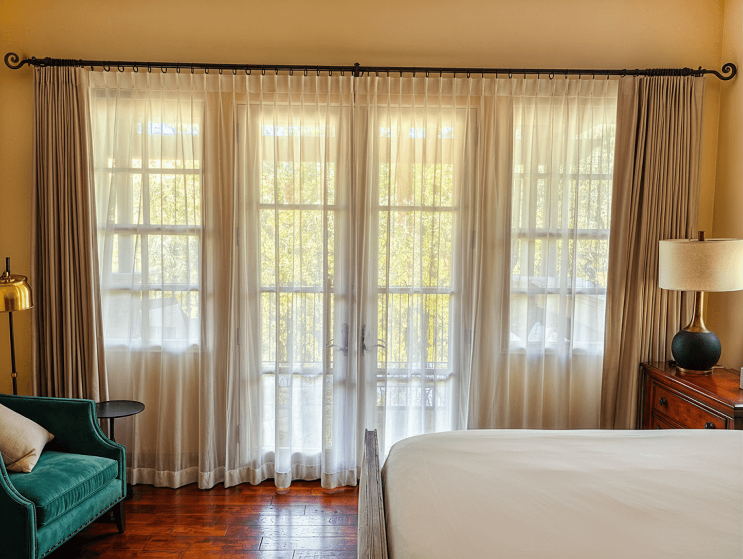 Custom single-pleat drapery detail with layered sheer panels and premium wood hardware in a luxury residential interior.