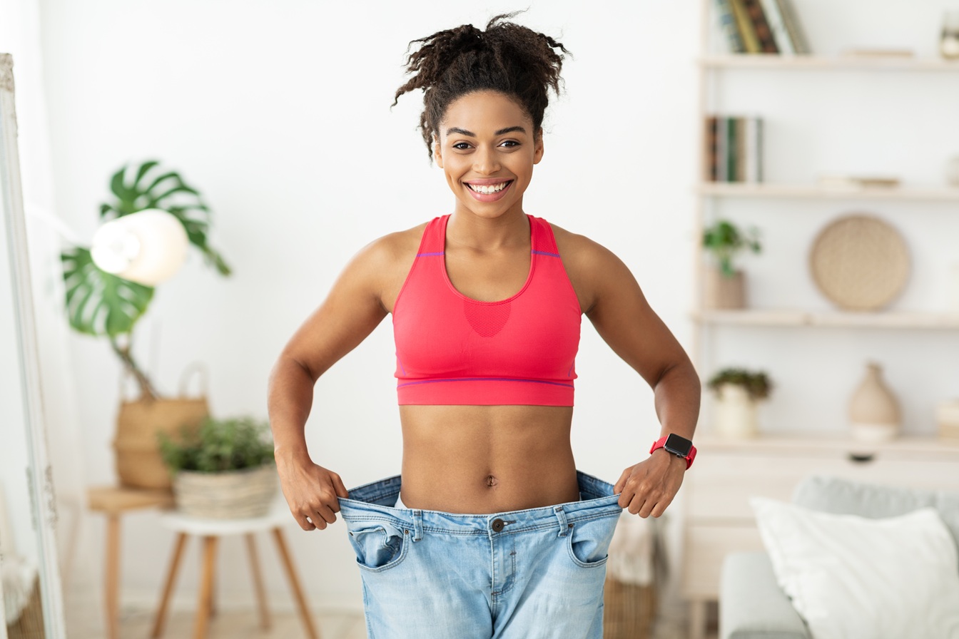 Personal trainer assisting client with proper form for metabolic health