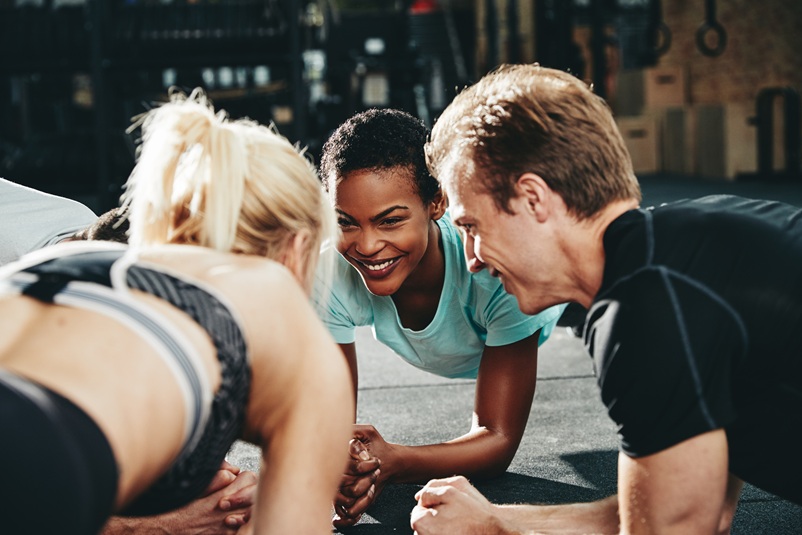A happy personal trainer cultivating a supportive fitness environment