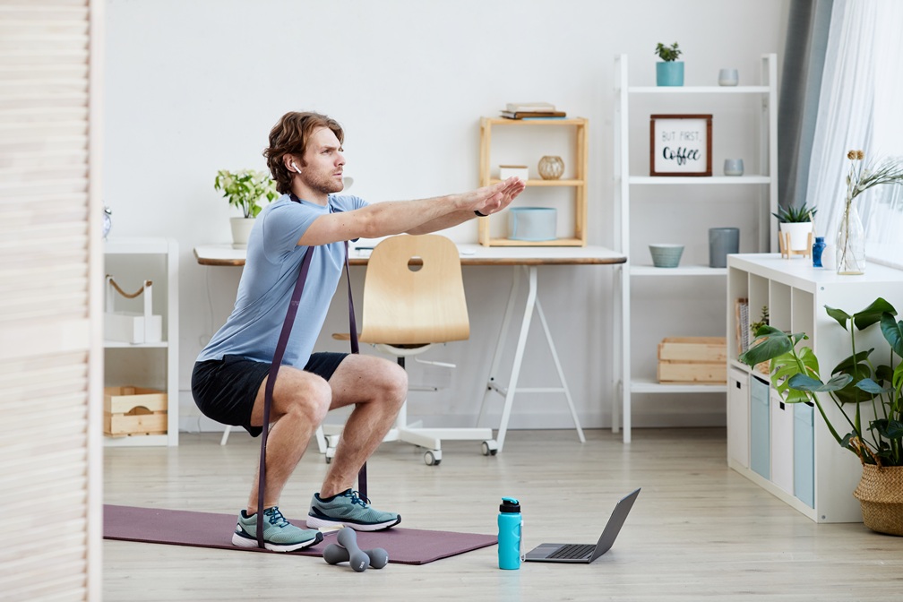 Man exercising in a gym, highlighting the benefits of in-person training over virtual workouts