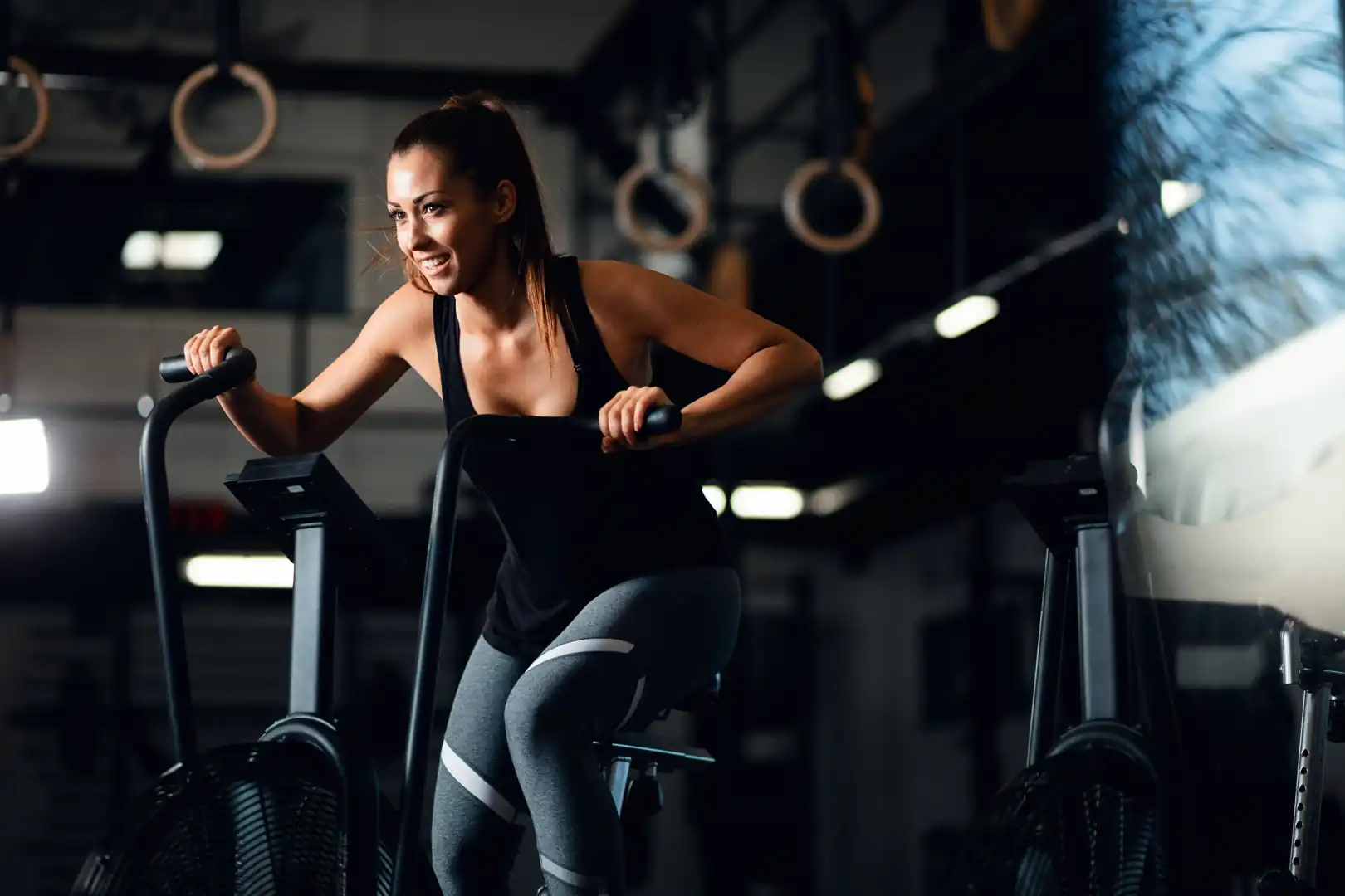 Fit woman pedaling on a fan bike during an energetic cardio exercise routine