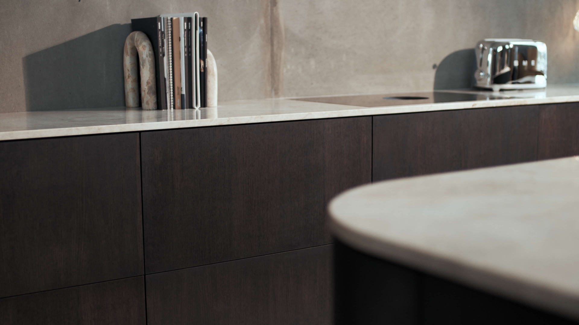 HJEMSTAVN is a high–end brand specialising in bespoke kitchens and interior solutions, with a strong emphasis on craftsmanship, quality materials and timeless design. Its design approach is inspired by the diversity of the world, while remaining firmly rooted in Danish heritage. The kitchen is viewed as the heart of the home, and HJEMSTAVN aims to give spaces soul, transforming houses into homes. This balance between the global and the local gives each kitchen its distinctive character. While styles and expressions evolve, the brand’s DNA remains constant. A deep passion for design and materials drives a willingness to challenge industry–standard solutions and rethink how kitchens are created.