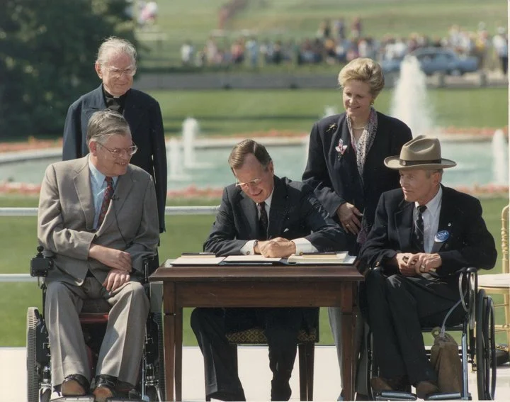 Image: George Bush signs the Americans with Disabilities Act into law in 1990.