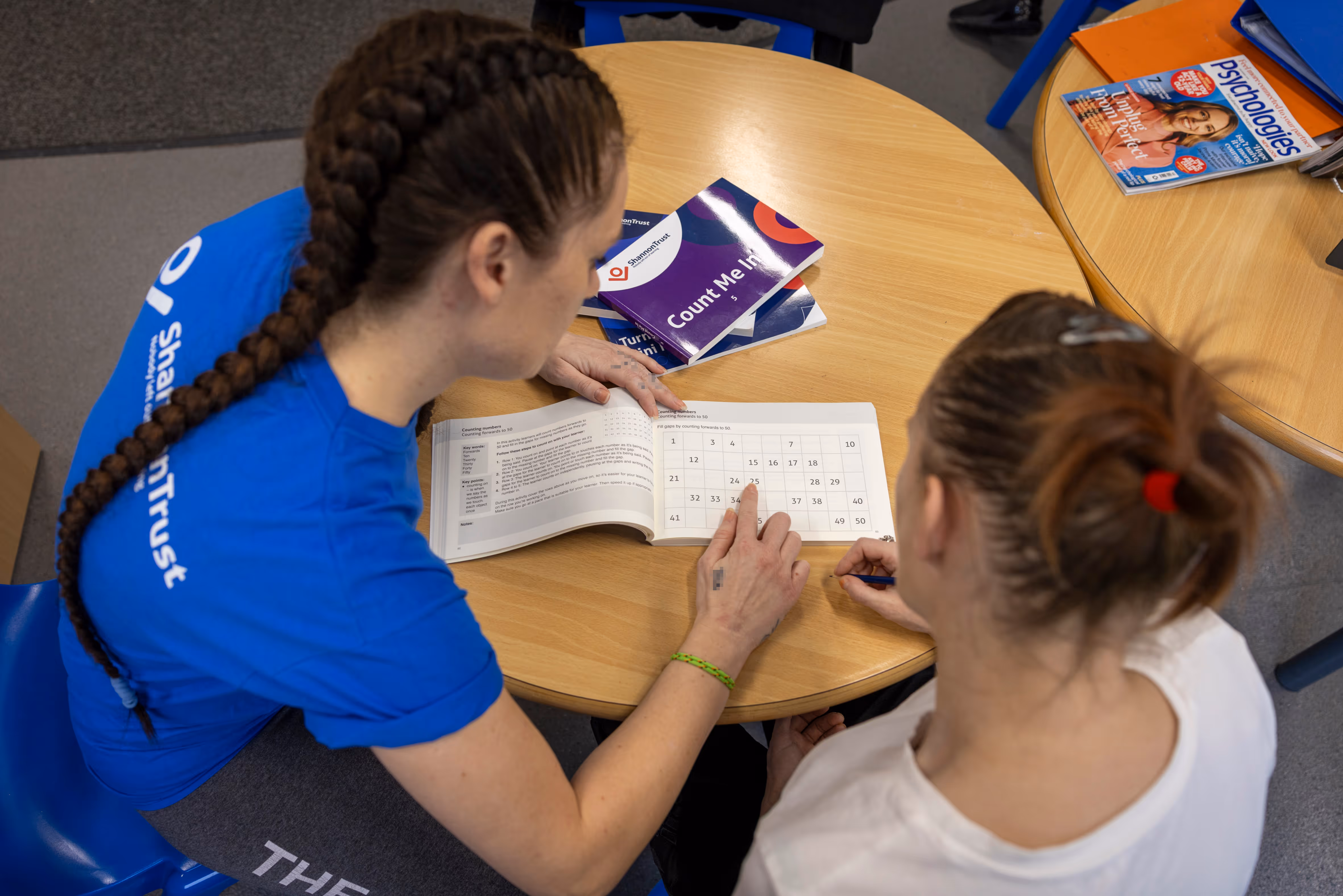 A mentor and a learner going though one of the Turning Pages manuals