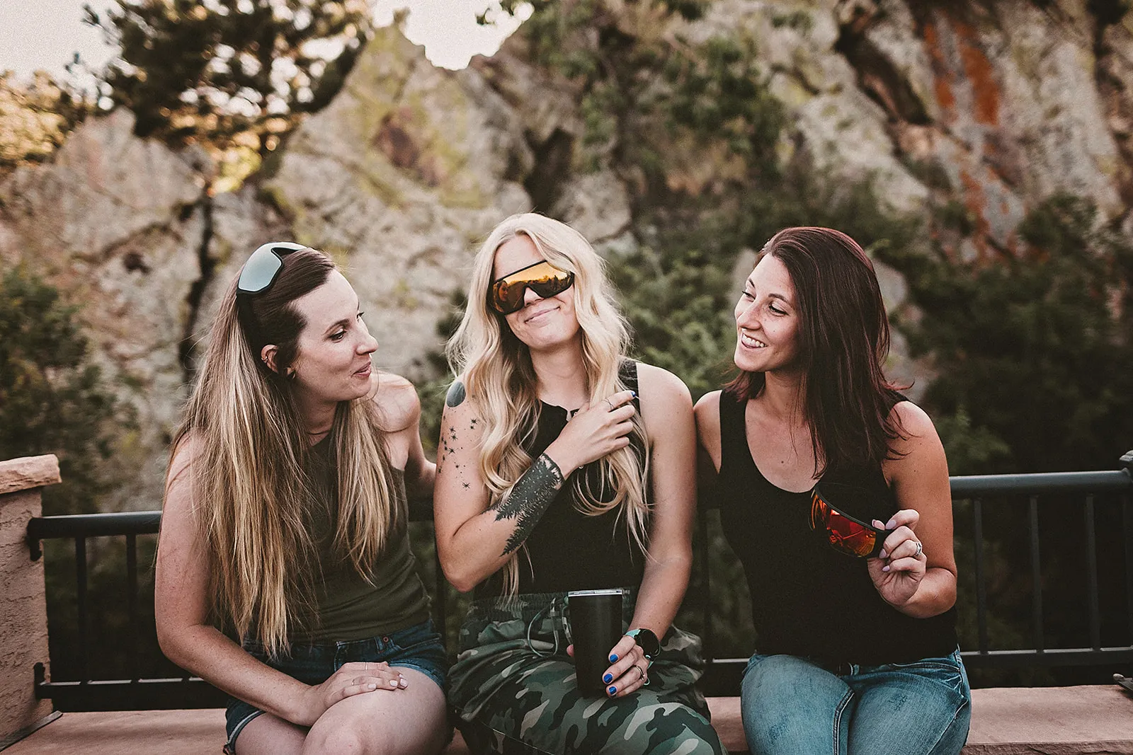 Three women sitting down with sunglasses
