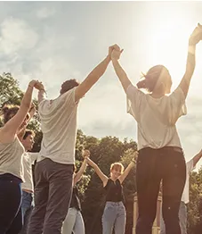 Gruppe von Menschen, die sich an den Händen halten und feiern.