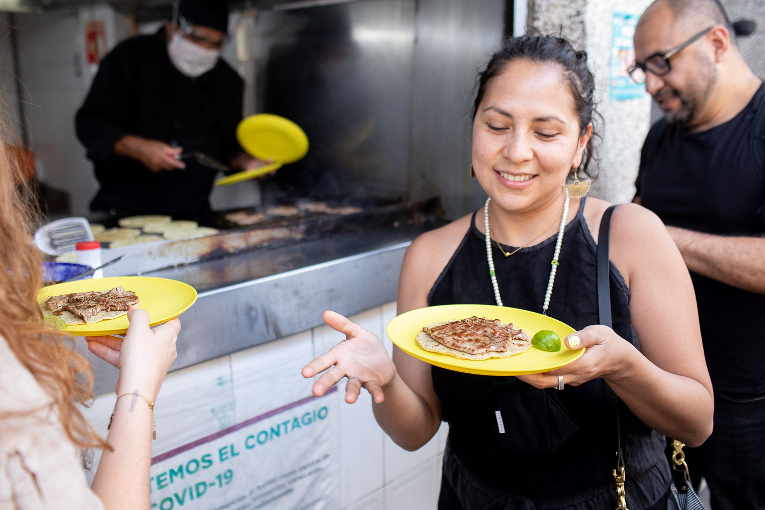 Anaïs holding a plate with food on it and smiling