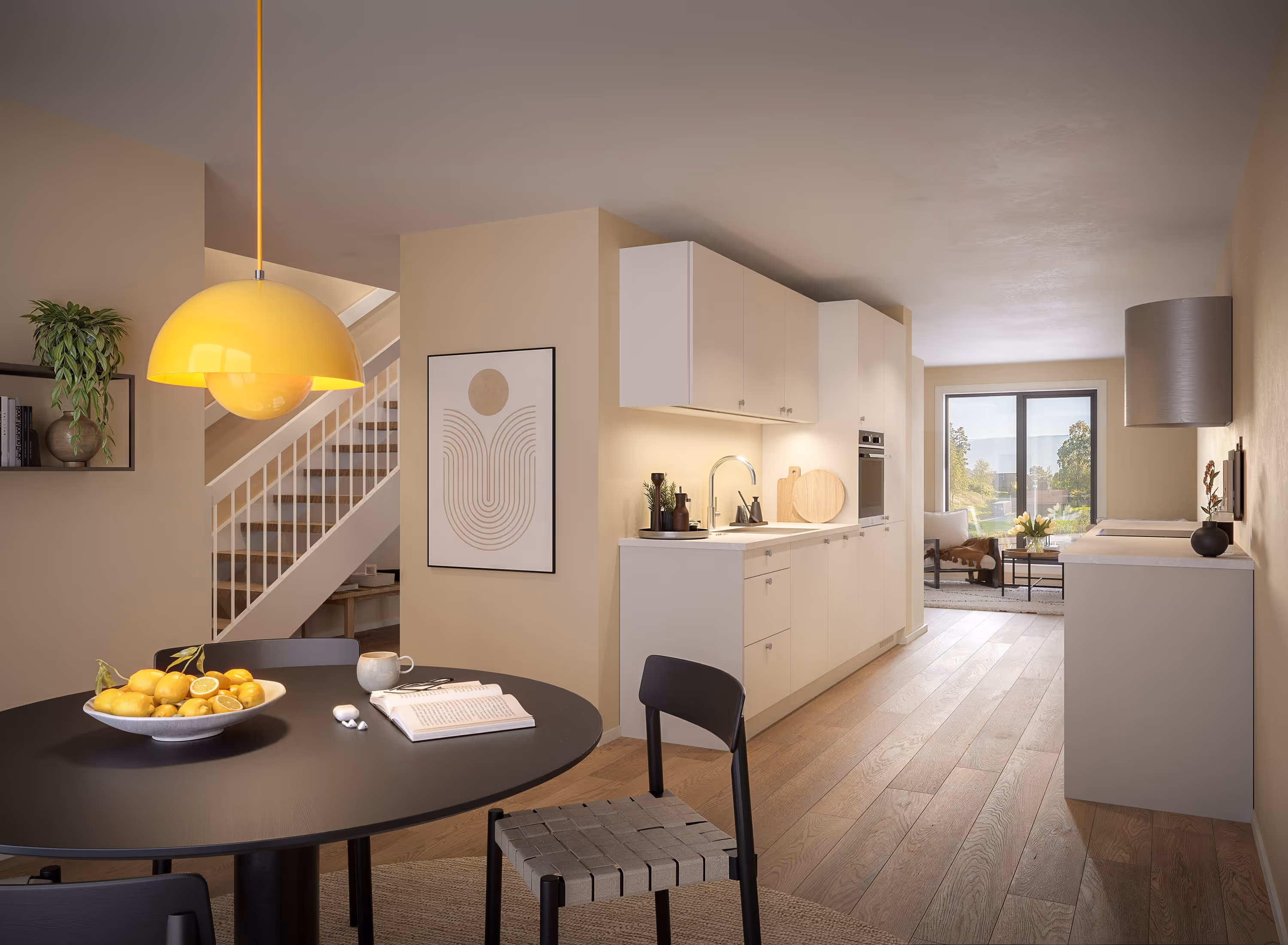 Modern open kitchen and dining area with wooden floor, black round table with lemons, yellow pendant light, and a view of a living room with a large window.