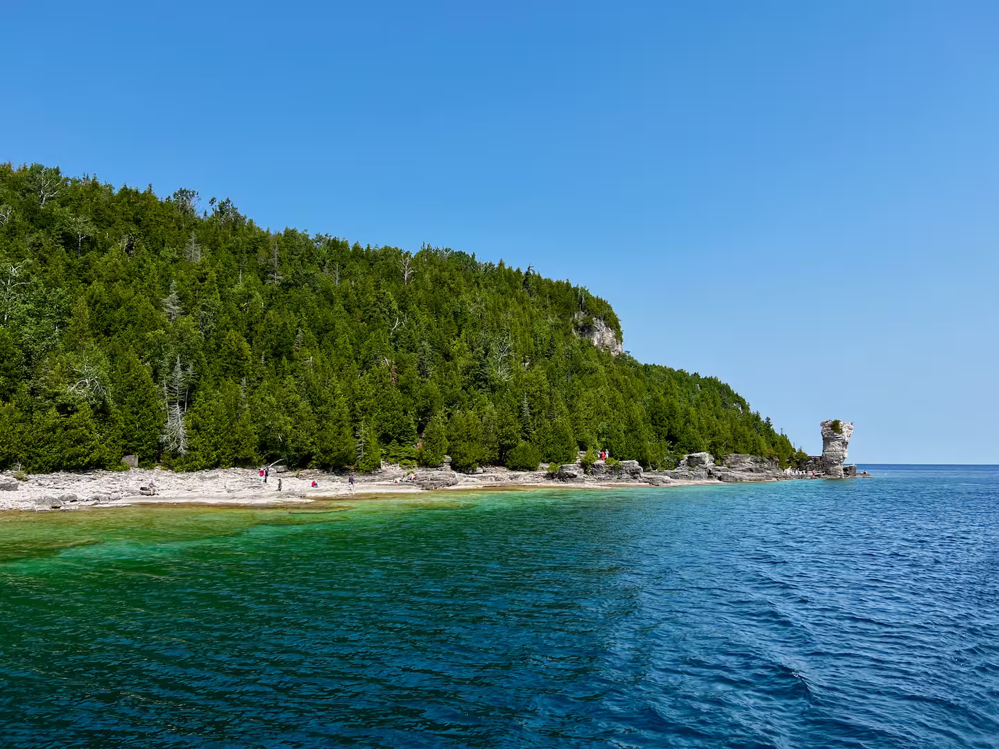 Photo of an island in Fathom Five National Park, with a flower pot structure on the right and blue waters around. Credit Adam Ballah.