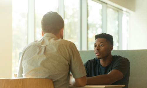Two colleagues talking at table