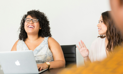 Three ladies sitting at table talking and laughing