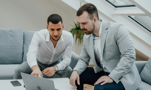 Two business men at laptop talking
