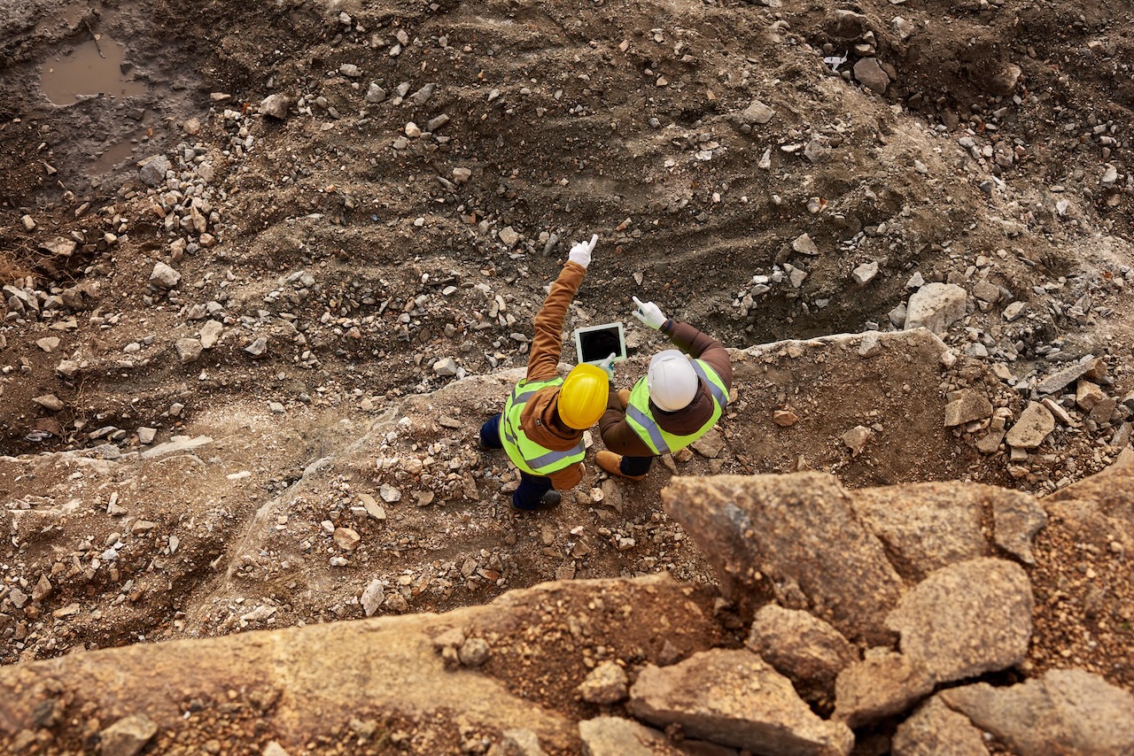 Two workers with a tablet surveying an industrial operations site