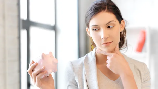 Ženska drži v roki hranilnik za denar