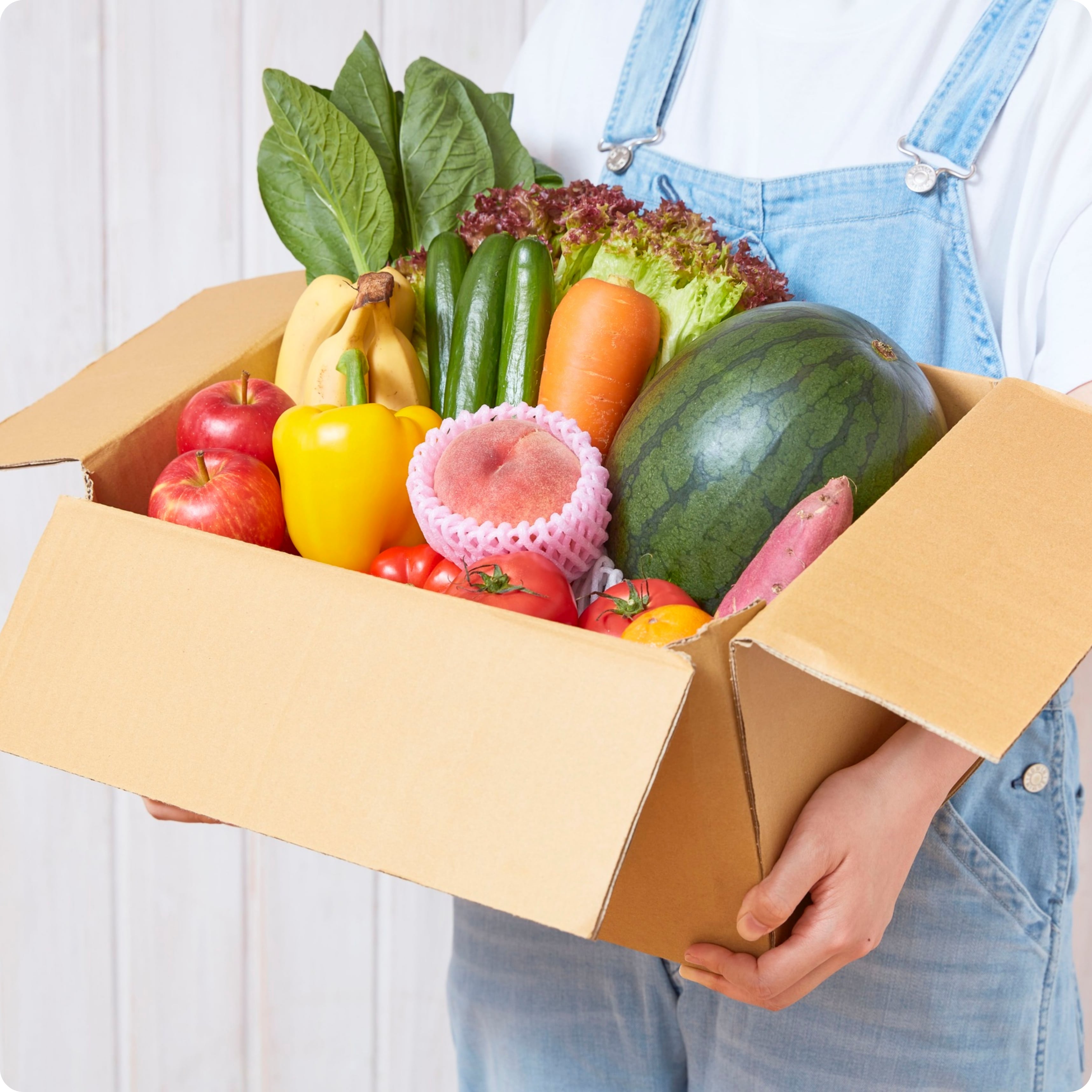 person holding pox of fresh fruits and vegetables