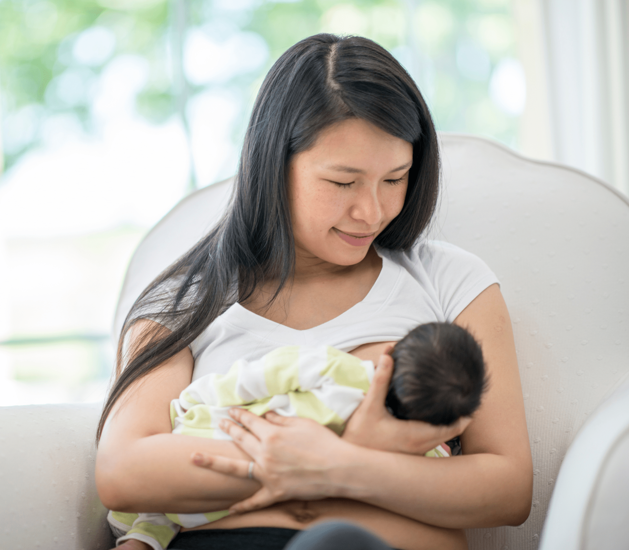 woman cradling child in her arms while sitting on a chair