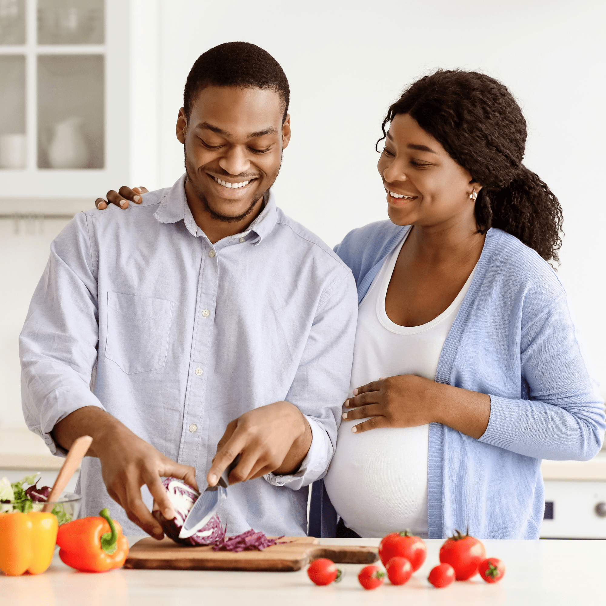 expecting couple chopping vegetables together