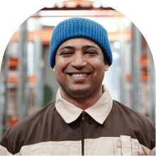 hispanic man in a beanie smiling at the camera