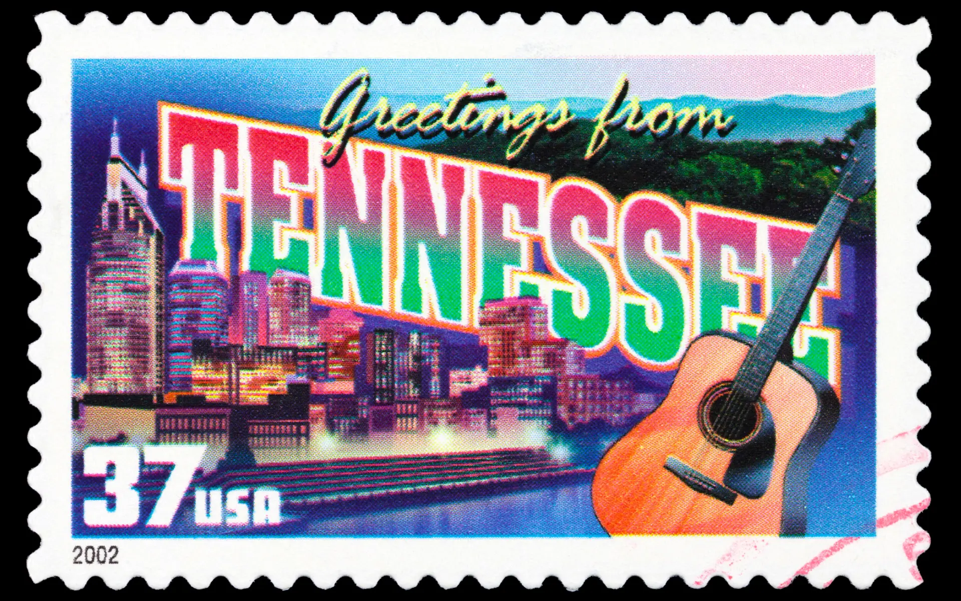 A colorful stamp design featuring the words "Greetings from Tennessee" in bold letters. The background shows a city skyline with illuminated buildings and a river. 