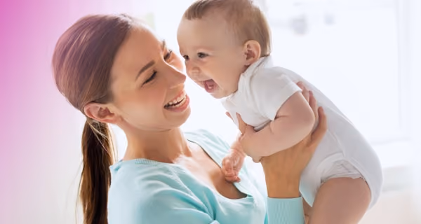 Mother lifting up a giggling baby