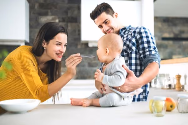 Young couple feeding their newborn baby